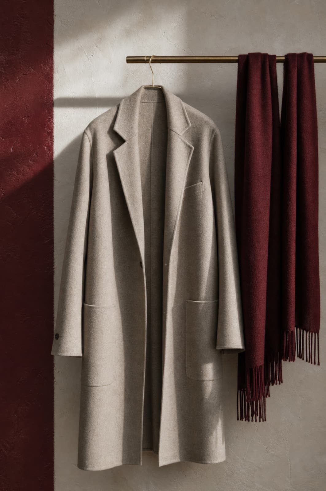 Cashmere-Blend Scarf, hung from a rail against limestone plaster.
