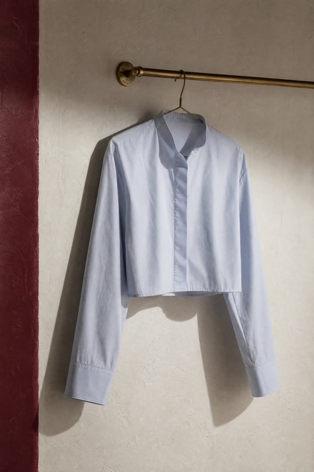 Cropped Blouse, hung from a rail against limestone plaster.
