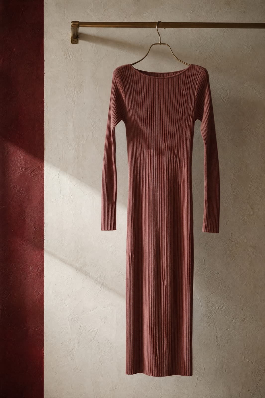 Knit Column Dress, hung from a rail against limestone plaster.