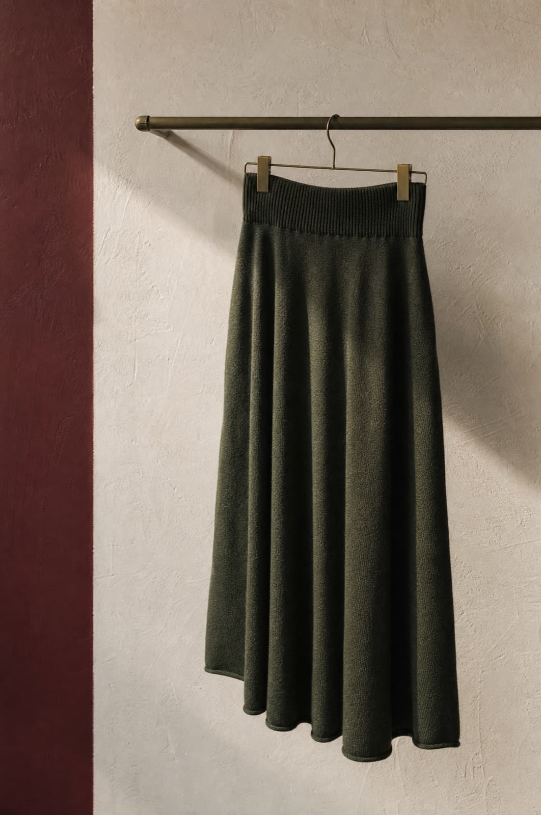Knit Skirt, hung from a rail against limestone plaster.