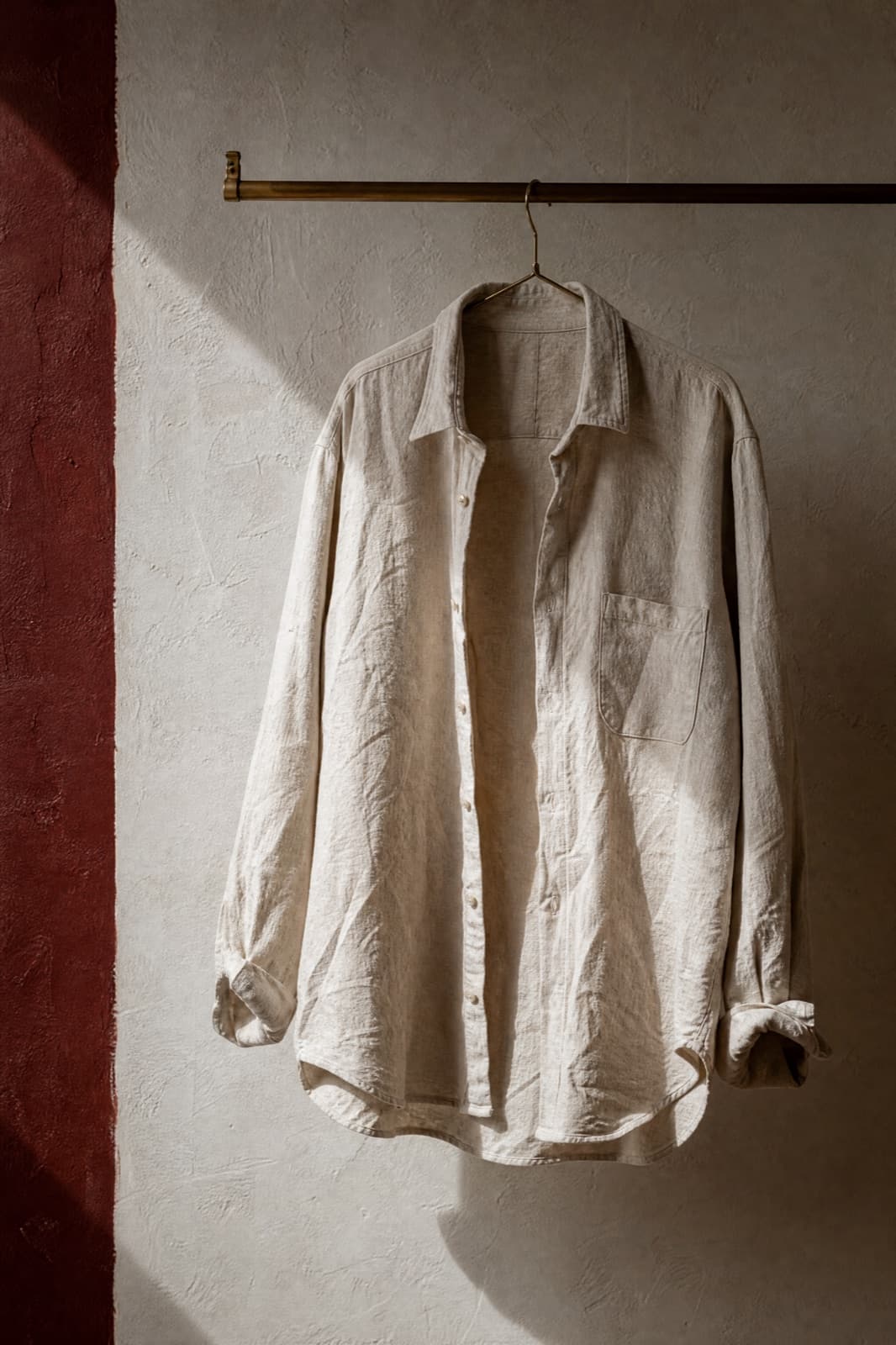 Linen Shirt, hung from a rail against limestone plaster.