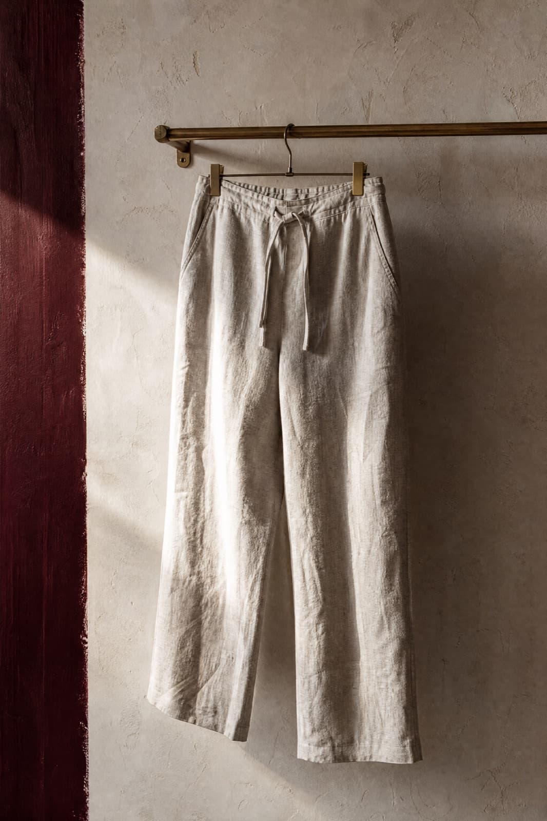 Linen Trouser, hung from a rail against limestone plaster.