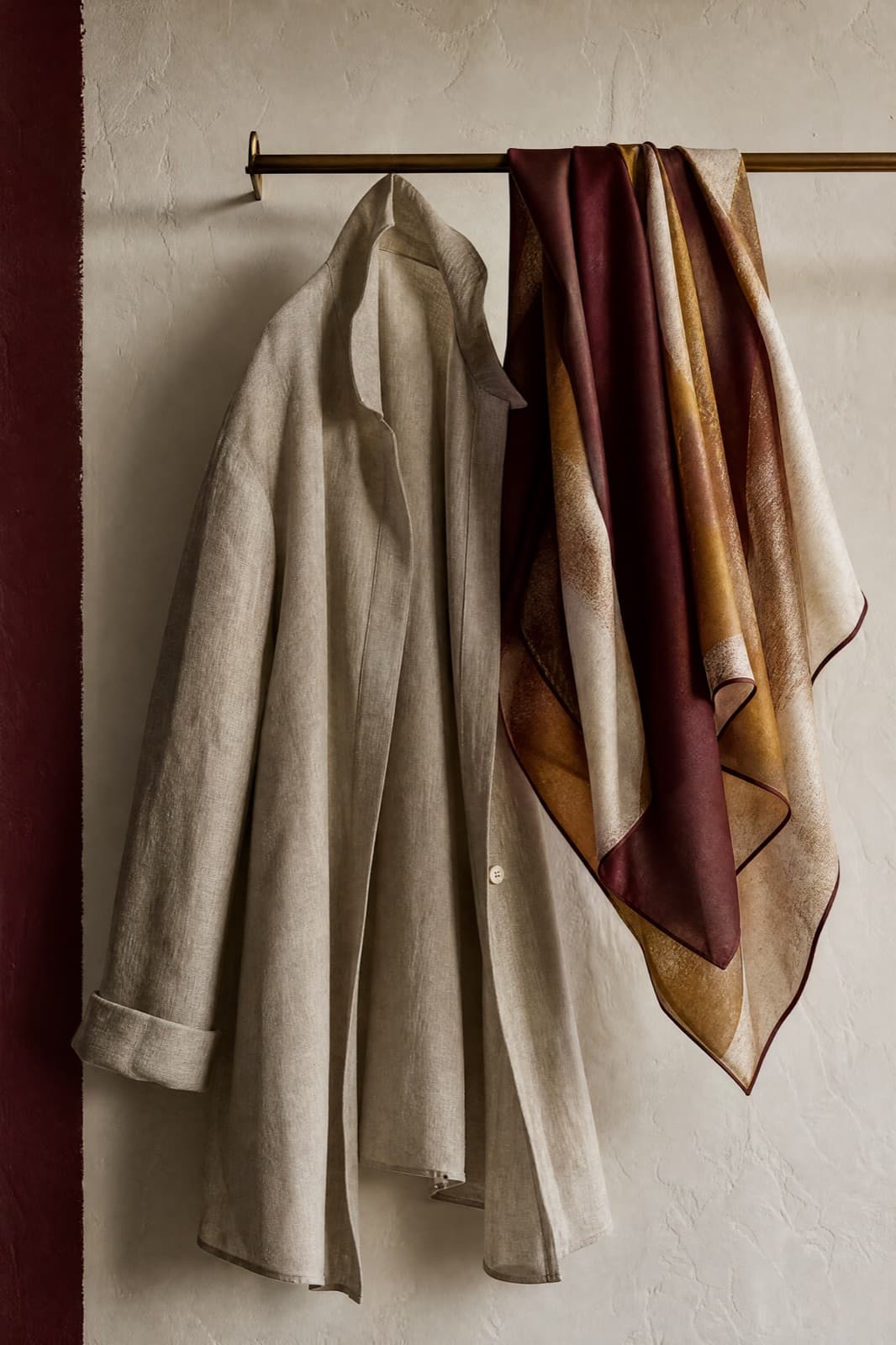 Silk-Blend Scarf Square, hung from a rail against limestone plaster.